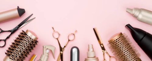 Various hair dresser tools on pink background with copy space